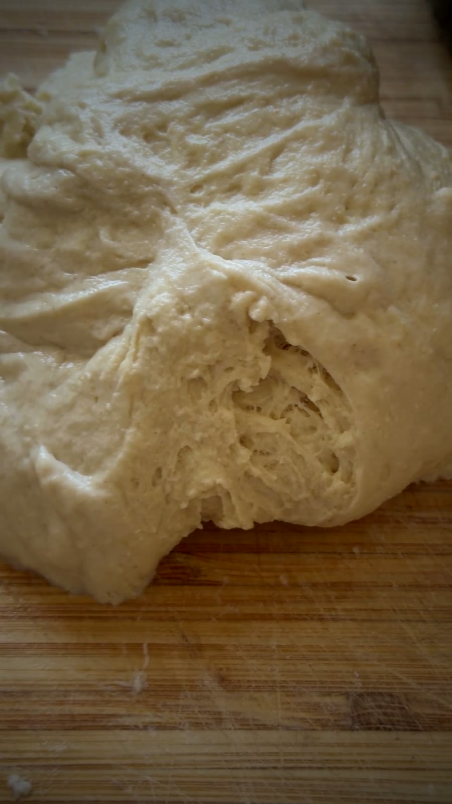 A ball of Corner Harvest pizza dough on a wooden board