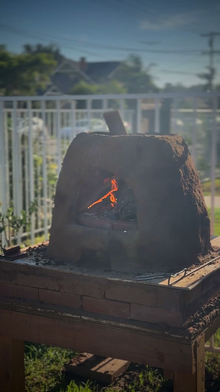 The Corner Harvest cob oven with a small fire burning inside